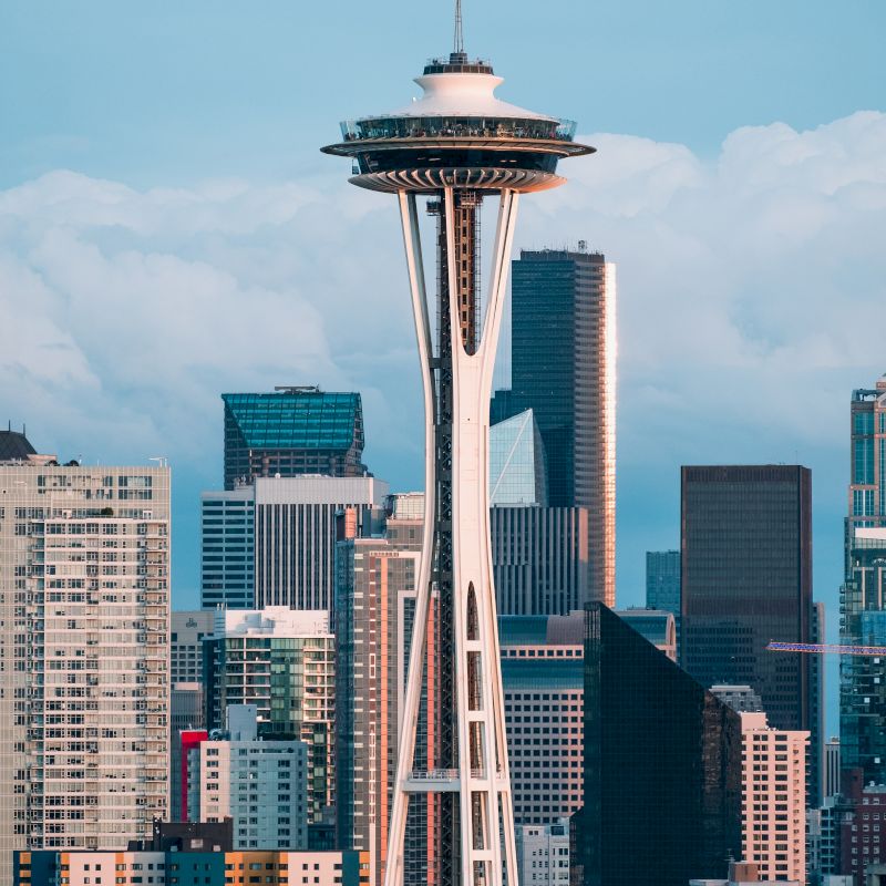 The image shows the Space Needle, a prominent observation tower, with the skyline of Seattle, Washington in the background.